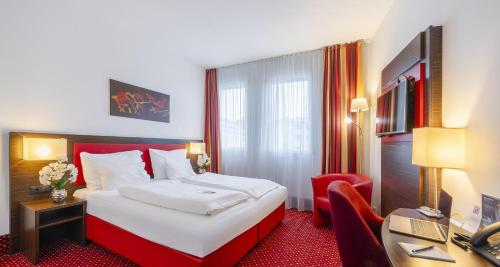 a hotel room with a bed and a desk at PLAZA INN Amedia Wien in Vienna