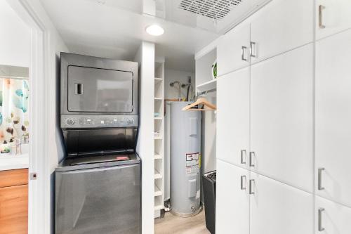 a kitchen with white cabinets and a microwave and a refrigerator at Compact Urban Living in DTPH, Pool in Phoenix