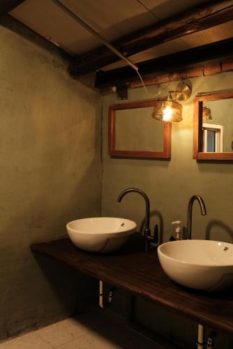 2 lavabos en un mostrador de madera en un baño en 尞 Liau 農村紅磚民宿, en Xinwu