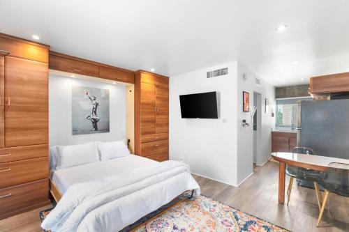 a bedroom with a bed and a table and a tv at Compact Urban Living in DTPH, Pool in Phoenix