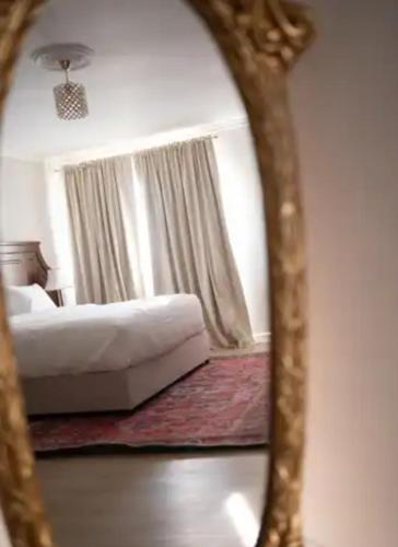 a reflection of a bedroom with a bed and a mirror at John Bull House in Buzău