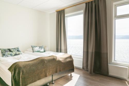 a bedroom with a bed and a large window at Hotel West in Patreksfjörður
