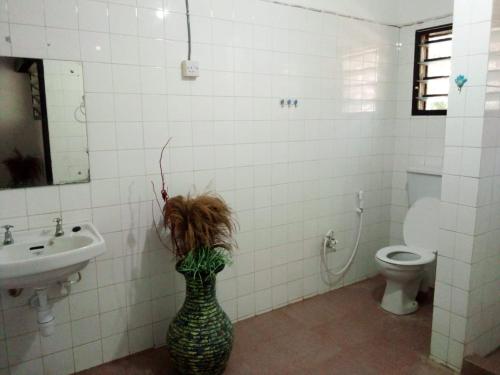 a bathroom with a vase in the corner of a bathroom at Allison Homes in Kilifi