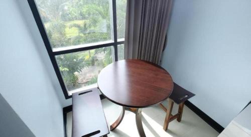 a table and a chair in front of a window at Sixty-Sixplace in Ban Khok Lo