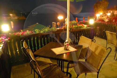 a table and chairs with an umbrella on a patio at Villa Jovan in Ohrid