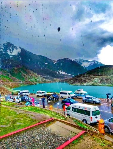 a group of cars parked in a parking lot next to a lake at Rozhok Hotel in Dargai
