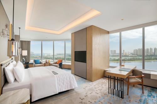 une chambre d'hôtel avec un grand lit et un bureau dans l'établissement Le Meridien Xi'an Chanba, à Xi'an