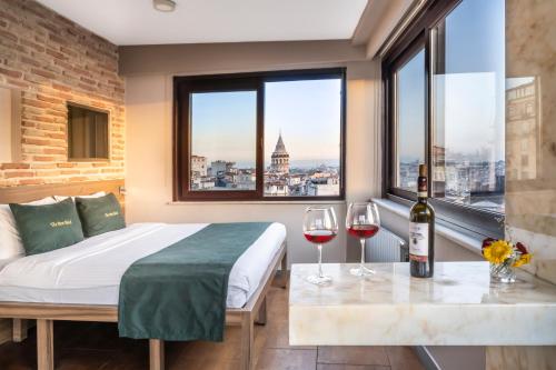 ein Schlafzimmer mit einem Bett und zwei Gläsern Wein in der Unterkunft The Pera Hotel in Istanbul