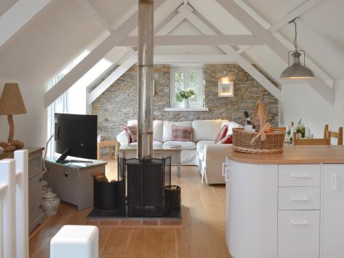 a kitchen and living room with a wood stove at Willow Barn in Saint Ewe