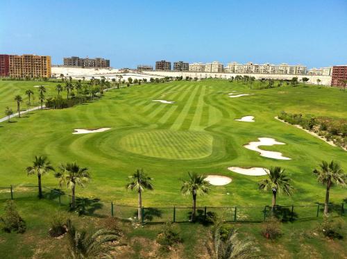 an aerial view of a golf course with palm trees at Apartment in Golf Porto Marina in El Alamein