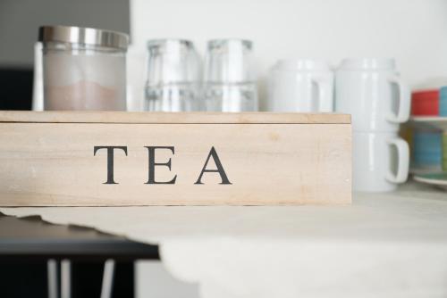 a wooden sign that says tea sitting on a shelf at Hotel West in Patreksfjörður