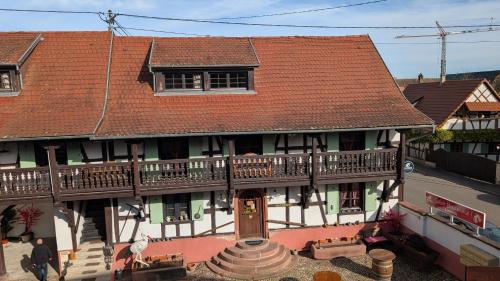 ein altes Haus mit einer Terrasse an der Seite in der Unterkunft Les Perles du Ried - Gîte 206 in Boofzheim