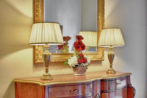 a table with two lamps and a mirror at Castello Conti Filo in Torre Santa Susanna