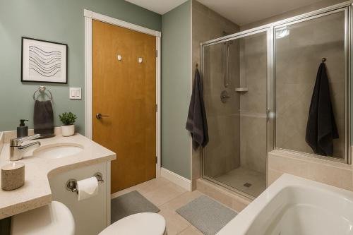 a bathroom with a shower and a toilet and a sink at Luxury 2-Bedroom Apartment in Coal Harbour with Stunning City Views in Vancouver