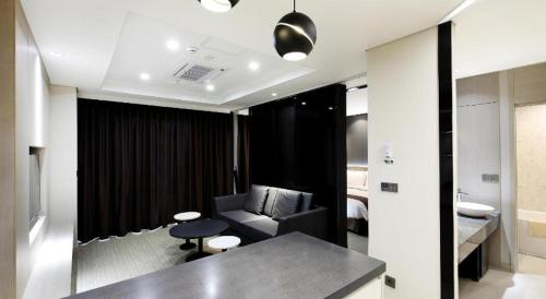 a living room with a couch and a chair at Gloucester Hotel Kintex in Isan