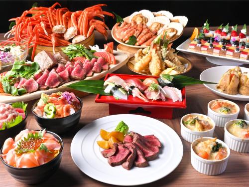 a table full of different types of food on plates at Hotel Abest Sapporo in Sapporo