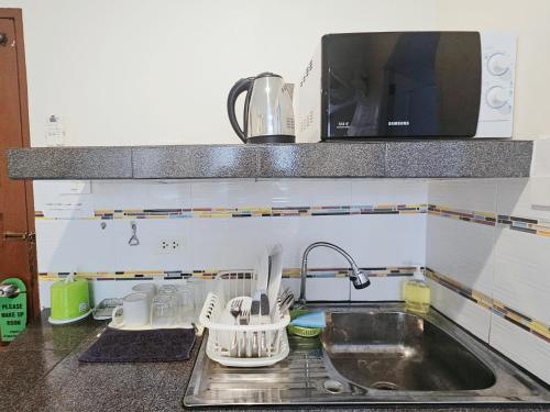 a kitchen counter with a sink and a microwave at Walking Street Guest House in Pattaya South