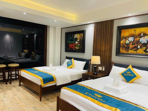 a hotel room with two beds and a living room at King Sea Hotel in Rạch Giá
