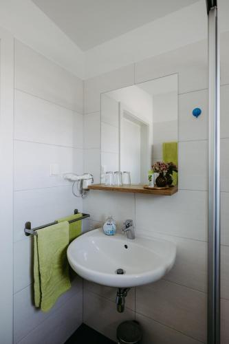 a white bathroom with a sink and a mirror at Sonnenweg Appartements in Rust