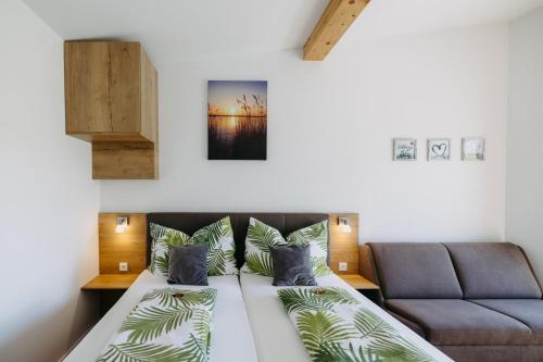 um quarto com uma cama e um sofá em Sonnenweg Appartements em Rust