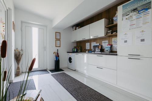 uma cozinha com armários brancos e uma máquina de lavar louça em Sonnenweg Appartements em Rust