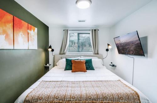 une chambre avec un grand lit blanc avec des oreillers orange dans l'établissement Spacious Downtown SLC, Cozy King Bed 2 Bed 1 Bath, à Salt Lake City