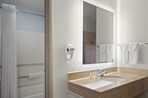 a bathroom with a sink and a mirror at Days Inn by Wyndham Las Vegas in Las Vegas