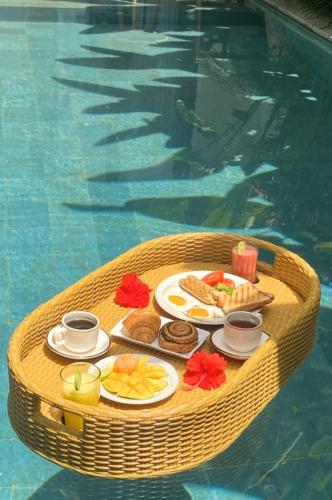 a tray of food on a table in a swimming pool at De Awan Villa in Kerobokan