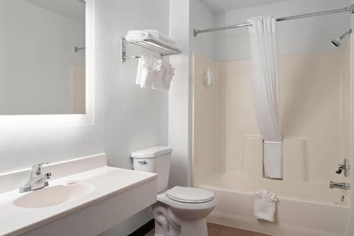 a white bathroom with a toilet and a sink at Days Inn by Wyndham Jamestown in Jamestown
