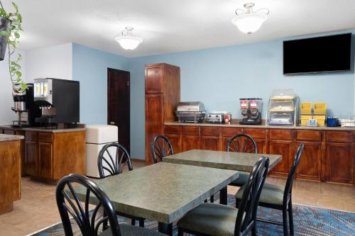 una sala da pranzo con tavolo e sedie e una cucina di Days Inn by Wyndham Jamestown a Jamestown