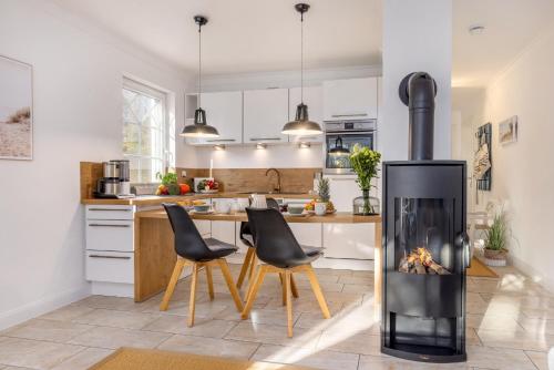 a kitchen with a fireplace in the middle of a room at Whg Dynamique in Zingst