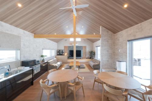 a kitchen and living room with two tables and chairs at HIGASHIKAWA Villa 瑞月 in Higashikawa