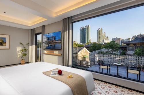 a bedroom with a large window with a view of the city at Palace House Guangzhou Yongqingfang Moon Bridge Store in Guangzhou