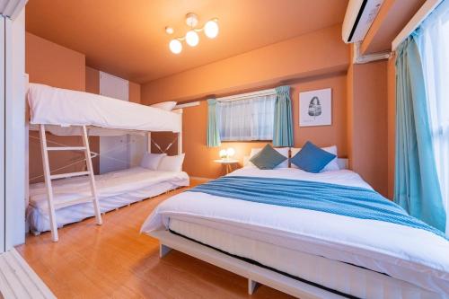 綺麗に改装されたアパートメント 京都や新大阪駅へアクセス良好 3ベッド 1バスルーム في أوساكا: غرفة نوم بسريرين بطابقين وسلم