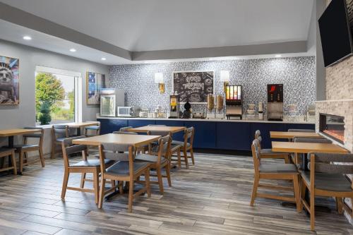 a restaurant with tables and chairs and a counter at AmericInn by Wyndham Urbana Champaign University Area in Champaign
