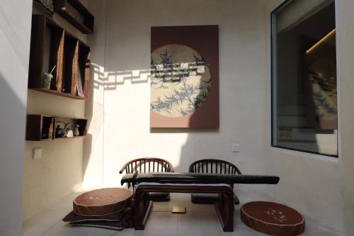 une table et deux chaises dans une pièce dans l'établissement Suzhou Garden Nook Pingjiang Laneway Hideaway, à Suzhou