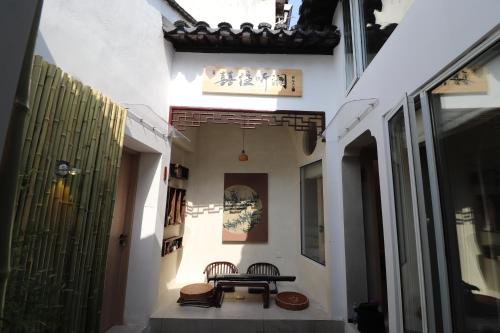 un pasillo con mesa y sillas en un edificio en Suzhou Garden Nook Pingjiang Laneway Hideaway, en Suzhou