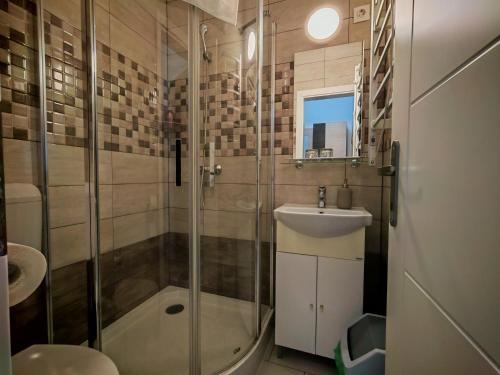 a bathroom with a shower and a sink at Menta Rooms & Bar in Kapuvár