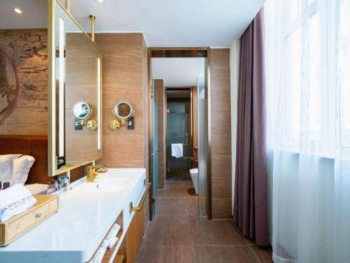 a bathroom with a sink and a mirror at James Joyce Coffetel Shenyang North Railway Station Qishan Road Metro Station in Shenyang