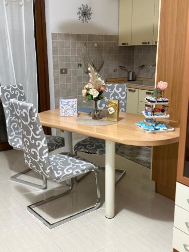 a kitchen with a wooden table and two chairs at Casa vacanza AIRPORT CALVO in Ronchi dei Legionari
