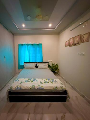 a bedroom with a bed with a blue curtain at Vididhi By N - 2BHK Neo Stay in Kottapeta