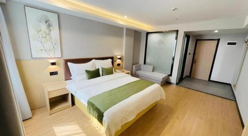ein Schlafzimmer mit einem großen Bett in einem Hotelzimmer in der Unterkunft GreenTree Inn Anhui Suzhou Baima Mall Express Hotel in Suzhou