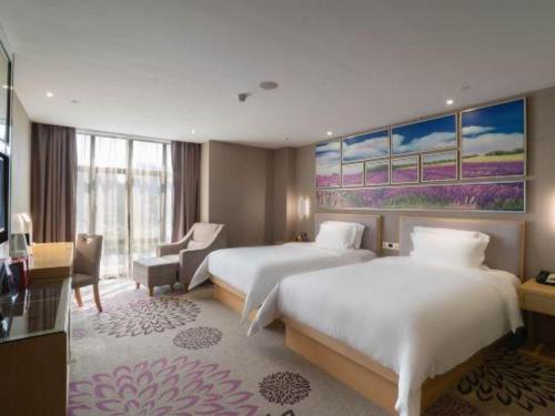 ein Hotelzimmer mit zwei Betten und einem Schreibtisch in der Unterkunft Lavande Hotel Foshan Shunde Shunlian Plaza Jinlong Metro Station in Shunde