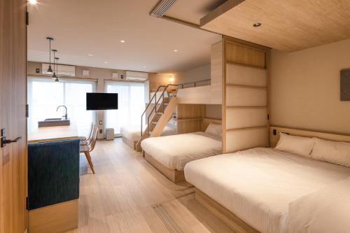a bedroom with two beds and a bunk bed at ALPHABED INN Hakata station front in Fukuoka