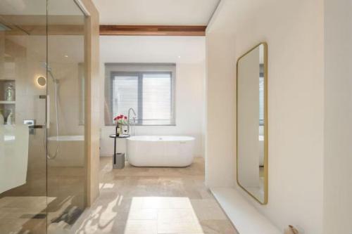 ein Badezimmer mit Badewanne, Dusche und Waschbecken in der Unterkunft Huazhu Luxury Huangshan Warm Wood Homestay Tangkou Nandamen Branch in Tangkou