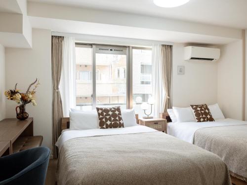 a hotel room with two beds and a window at RARE-EBISU BREEZE Apartment in Tokyo