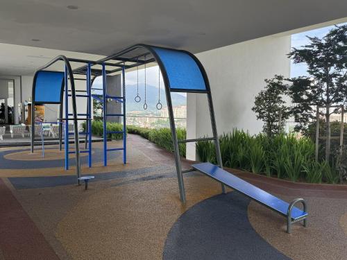 a playground with blue swings in a building at Urban Suites Staycation Spot by Twinkle Loft in George Town