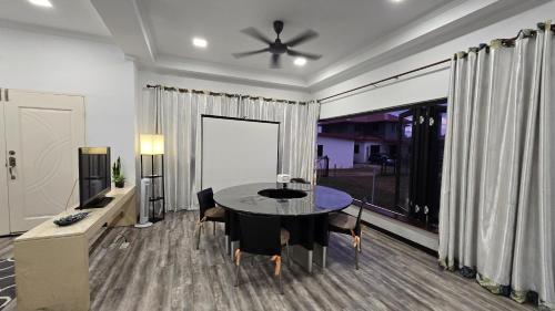 a dining room with a table and a ceiling fan at Tuaran Village Guesthouse in Tuaran
