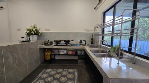 a kitchen with a sink and a counter top at Tuaran Village Guesthouse in Tuaran