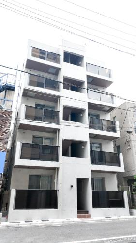 a white building with balconies on the side of it at 9Stay上野入谷 in Tokyo